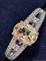 Top view of ring showing oval yellow center stone and clear accent stones