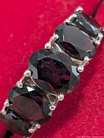 Top view showing five oval garnets in prong settings