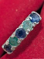 Close-up of band showing alternating sapphire and emerald stones