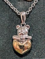 close-up of pendant showing teddy bear and heart with diamond