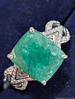 Top view of ring showing cushion dyed emerald and pave shank