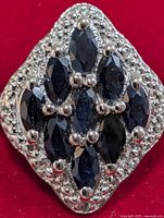 front view of silver ring with cluster of sapphires