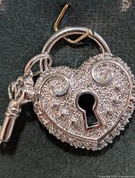 Front view showing heart lock shape, CZ border, keyhole, attached key charm