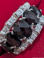 Front view showing five oval garnets and clear accent stones