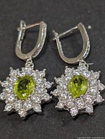 Frontal view of both silver peridot and CZ earrings
