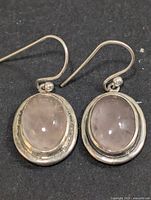 front view of both rose quartz silver earrings laying flat