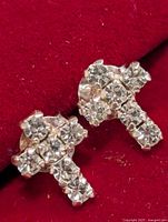 Front view of the earrings showing cross shape and clear stones