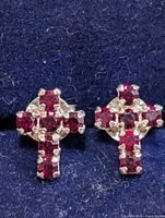 Front view of both cross stud earrings showing red stones and silver prongs