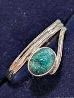 Top view of silver bypass ring showing oval emerald cabochon