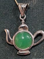 Front view of silver teapot pendant with green onyx center