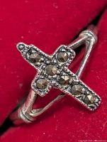 Front view showing cross with dark stones on red background