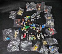 Overview of multiple zip bags with minifigure parts, small bricks and sealed minifigure packs