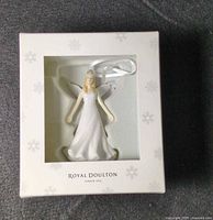 Front of boxed Royal Doulton angel ornament showing figurine through window
