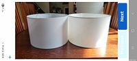 two off-white cylindrical lamp shades side by side