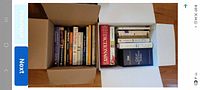 Two open boxes showing all spines of assorted books