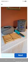 Group shot showing all four items: neck pillow, Desk Jockey cushion, spiky roller stick, wooden foot roller