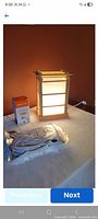 Lamp, boxed cord, boxed bulb on table
