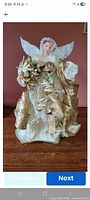 Front view of ivory and gold angel showing gown, bouquet, wings