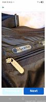 Close-up of LeSportsac logo label and zipper pull on front pocket
