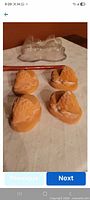 Four terra cotta hedgehog feet with clear view of shape and one clear glass object in background