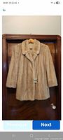 Full front view of palomino mink fur jacket on hanger