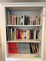 Three shelves of bookcase showing all volumes