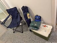 Group shot showing Coleman cooler, two folded blankets, lunch bag, folded camp chair in sleeve, assembled camp chair