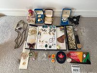 Full lot overview showing necklaces, bracelets, earrings, brooches, pins, watches and display boxes