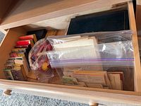 Drawer showing multiple card decks, bridge tally sheets in bags