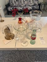 Full lot view on table showing clock, various glass pieces, Coca-Cola bottle