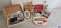 Overview of entire lot showing basket, bin, framed needlepoint, knitting tools and box of notions