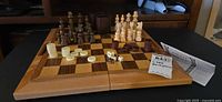 Open folding wooden chess/backgammon board with all pieces, discs, dice and paper visible