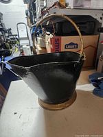 Full view of black coal scuttle on table