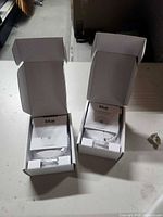 Two open boxes showing contents of Blue by ADT smoke detectors