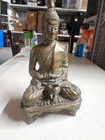 Front view of cast brass seated Buddha on base