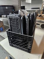Milk crate containing multiple keyboards standing upright