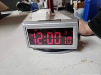 Front view showing illuminated red LED display reading 12:00