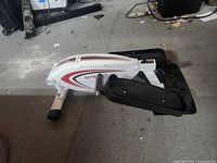 Left side view of FitDesk elliptical showing flywheel housing and one pedal