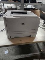 Front angled view of HP LaserJet P2035 printer powered on