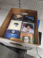 Top view of box showing several CD jewel cases including Eric Clapton and Natalie Merchant titles