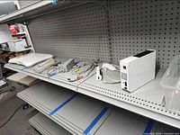 Shelf view with Wii console, cables, Balance Board, remote, Nunchuk, stand