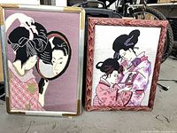 Both framed needlepoints side by side