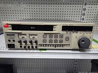 Front view of Panasonic S-VHS VCR showing controls, display, jog/shuttle dial