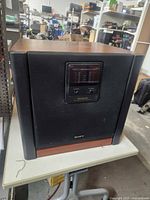 Front view showing Sony SEN-R5400 subwoofer with display panel and woodgrain top