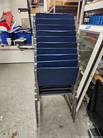Front view of stacked chairs showing blue vinyl seats and backs