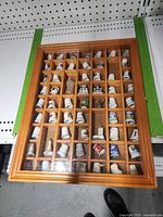 Front view of first wooden display case filled with souvenir thimbles