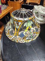 Side view of Tiffany-style stained glass lamp shade showing floral design and condition