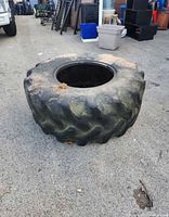 Full view of the large tractor tire sitting on pavement