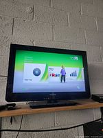 Television displaying Xbox 360 dashboard showing console powers on