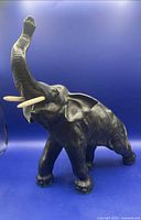 Right front view showing overall form, raised trunk and replacement tusks